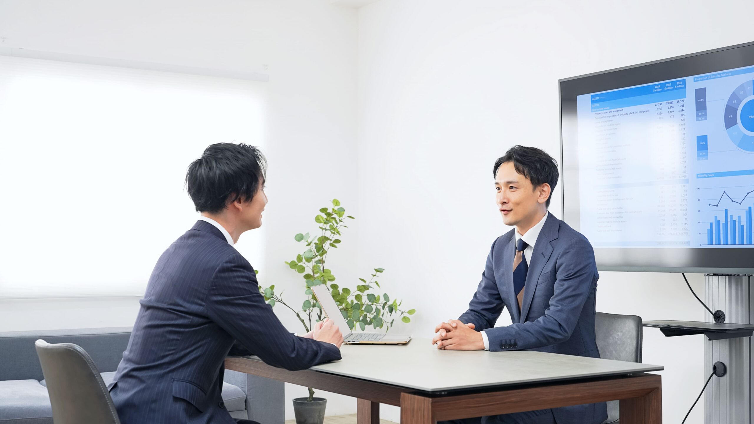 業績レポートを見ながら役員報酬を議論する経営者と税理士